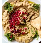 baba ghanouj garnished with pomegranate, parsley and olive oil