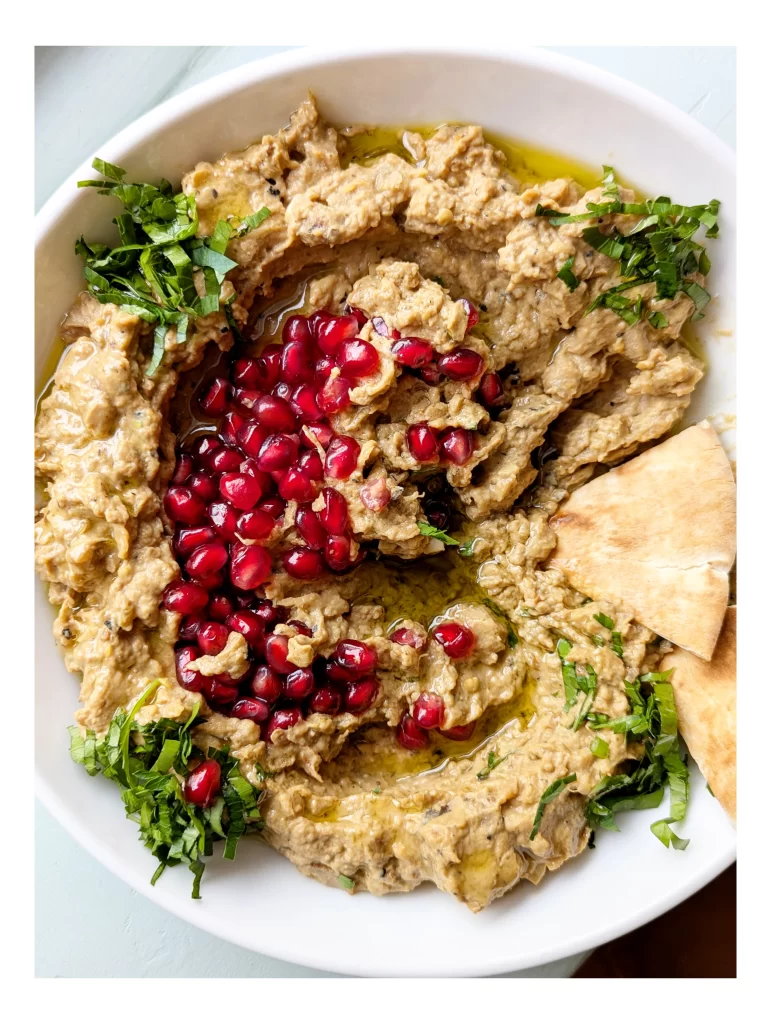 baba ghanouj garnished with pomegranate, parsley and olive oil