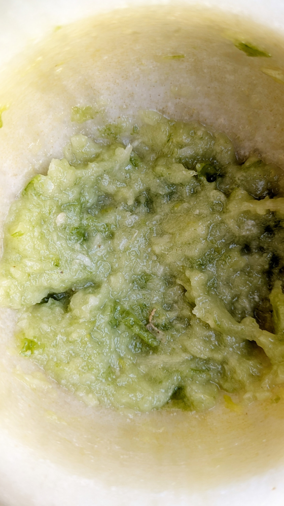 Mashed garlic, chili pepper, and salt in mortar and pestle